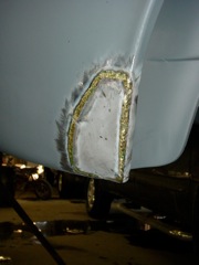 Trailing edge of passenger rear wheel well